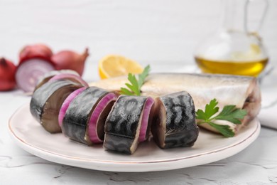 Tasty salted mackerel, parsley and onion on white textured table, closeup