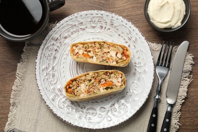 Photo of Pieces of delicious strudel with chicken and vegetables served on wooden table, flat lay