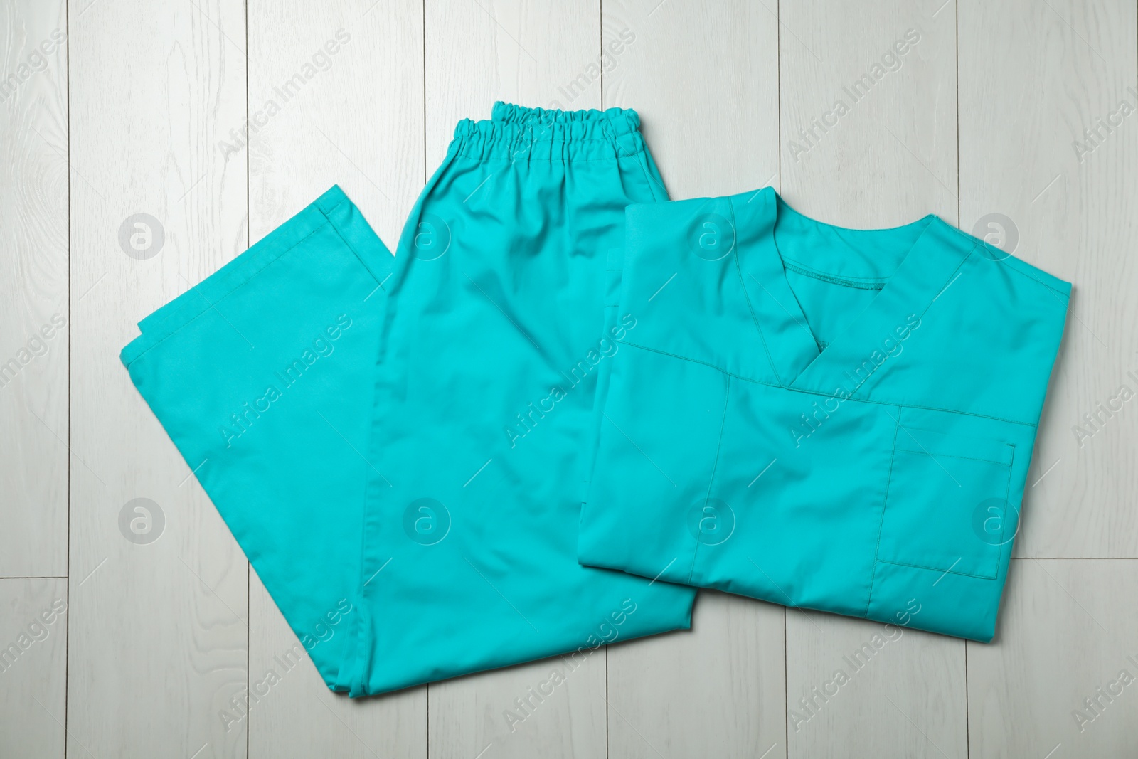 Photo of Clean scrubs on wooden background, top view. Medical objects
