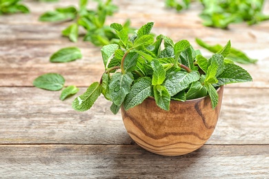 Bowl with fresh mint on wooden table