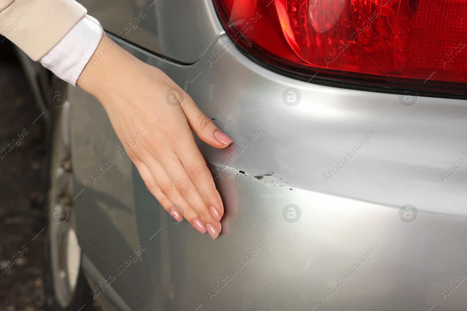 Photo of Woman near car with scratch outdoors, closeup view