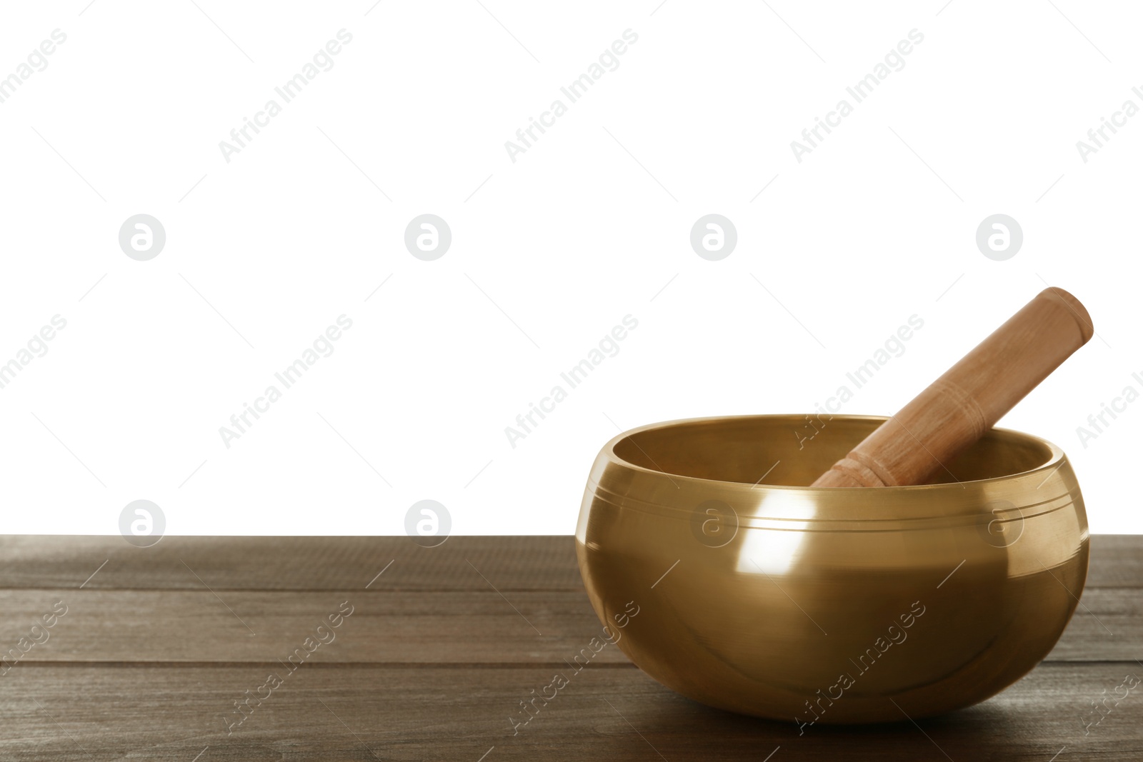 Photo of Golden singing bowl and mallet on wooden table against white background, space for text