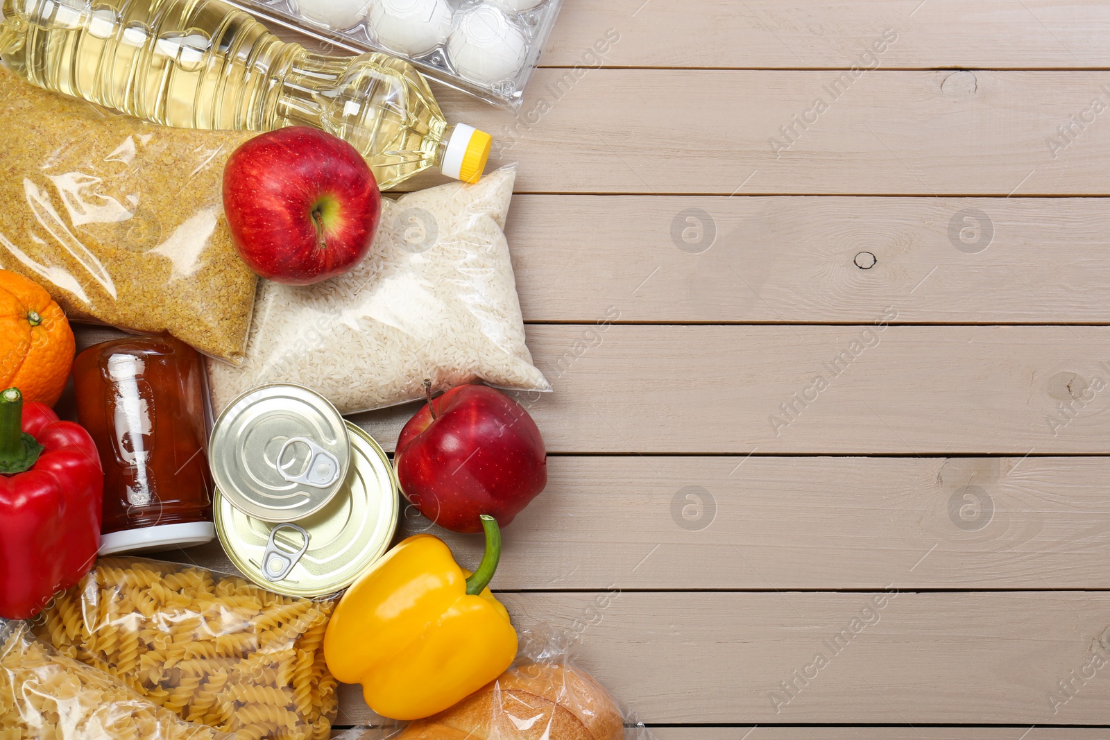 Photo of Different donation food on wooden table, flat lay. Space for text