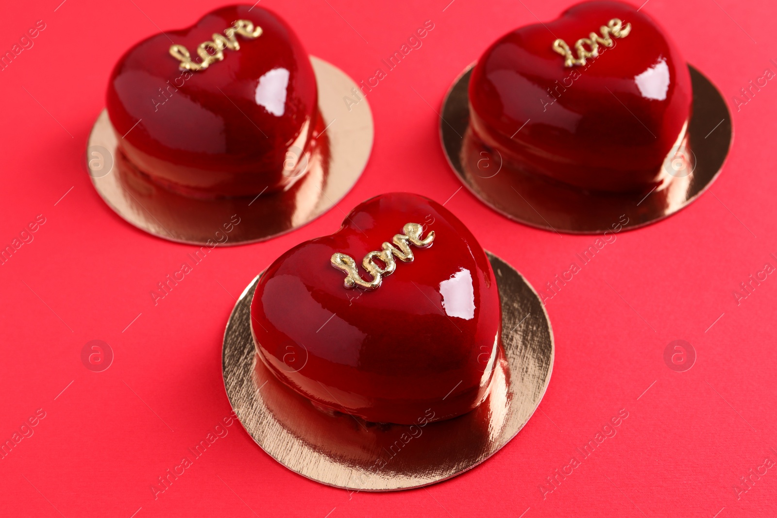 Photo of St. Valentine's Day. Delicious heart shaped cakes on red background, closeup