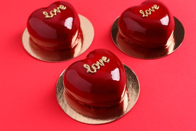 St. Valentine's Day. Delicious heart shaped cakes on red background, closeup