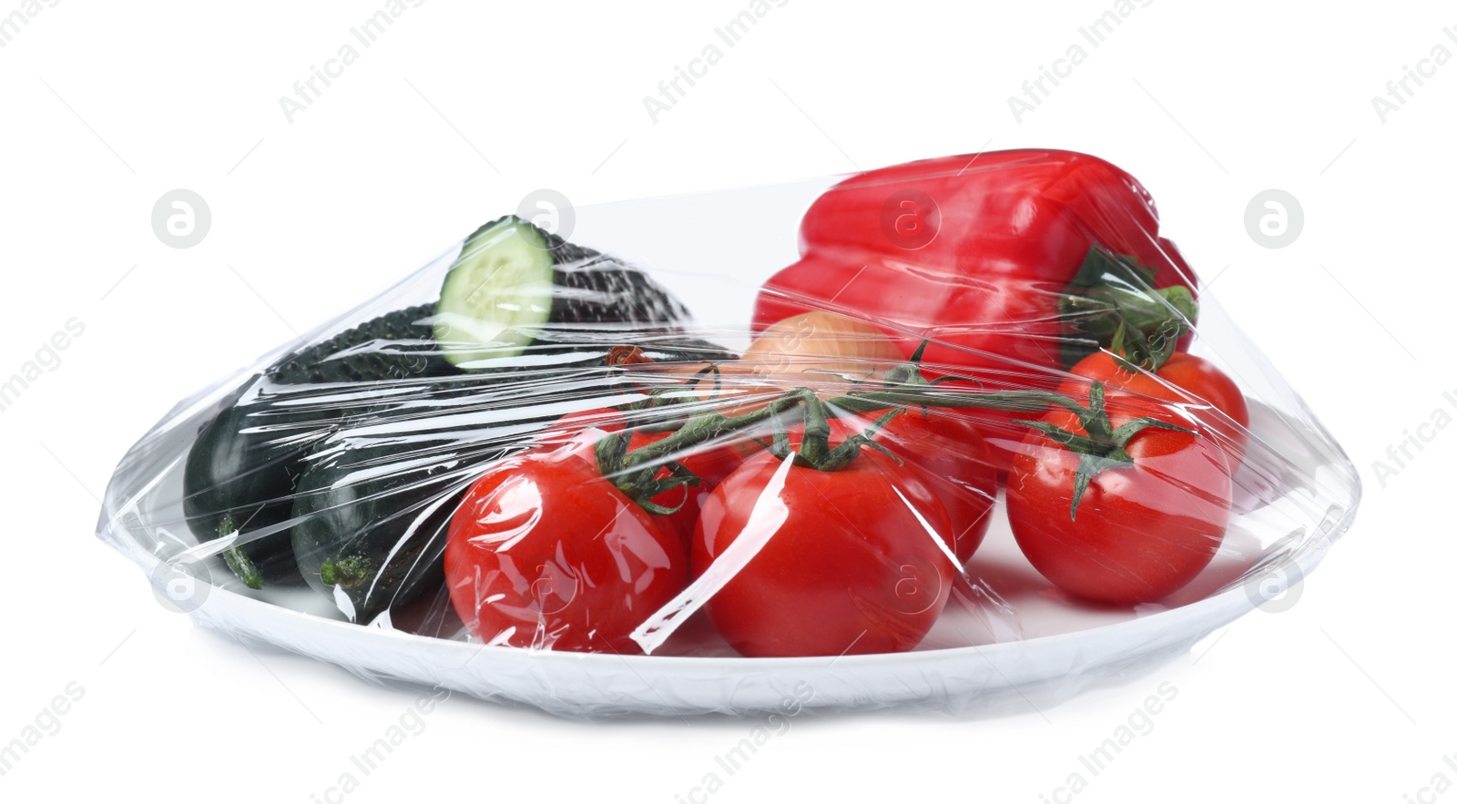 Photo of Plate of fresh vegetables wrapped with transparent plastic stretch film isolated on white