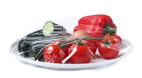 Photo of Plate of fresh vegetables wrapped with transparent plastic stretch film isolated on white