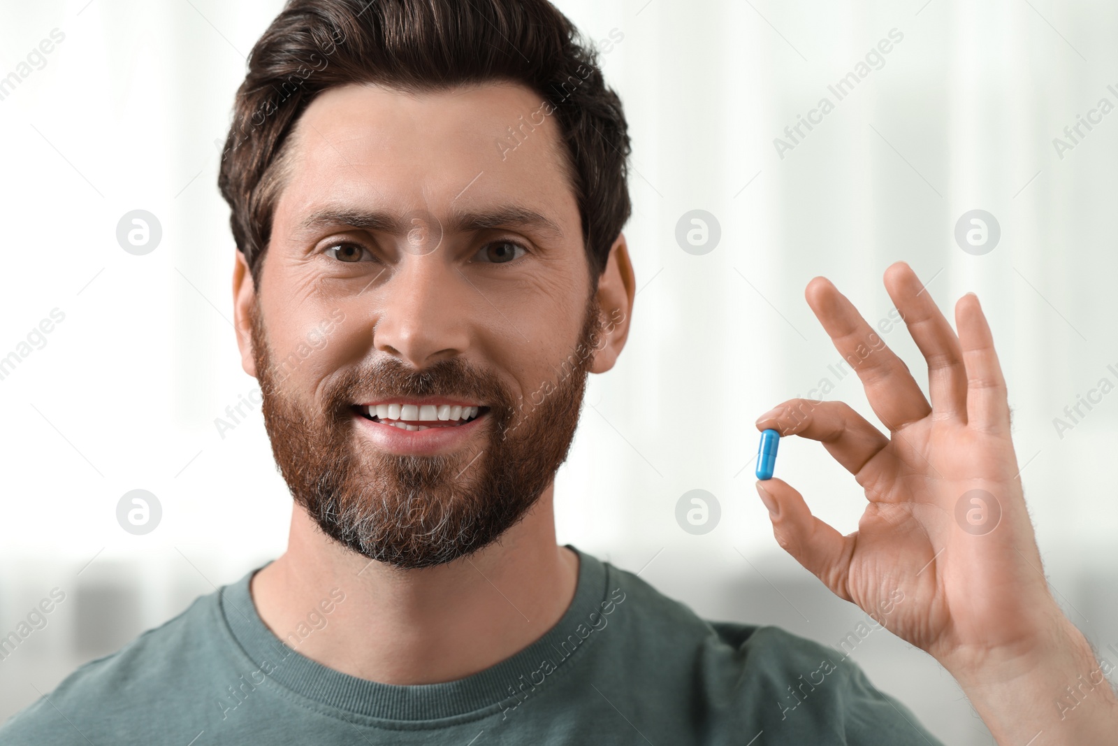 Photo of Portrait of handsome man with pill indoors