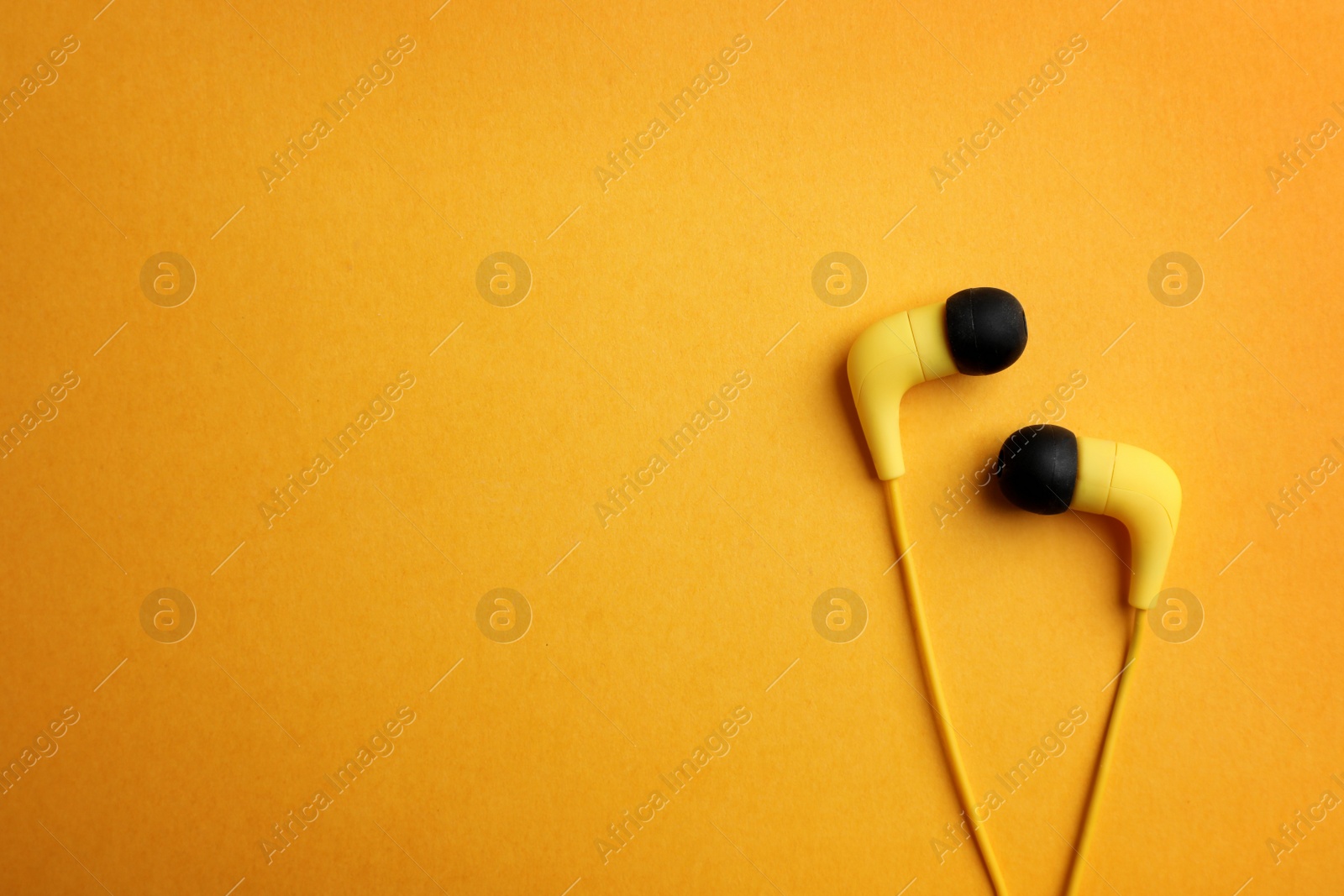 Photo of Stylish headphones on color background, top view. Space for text