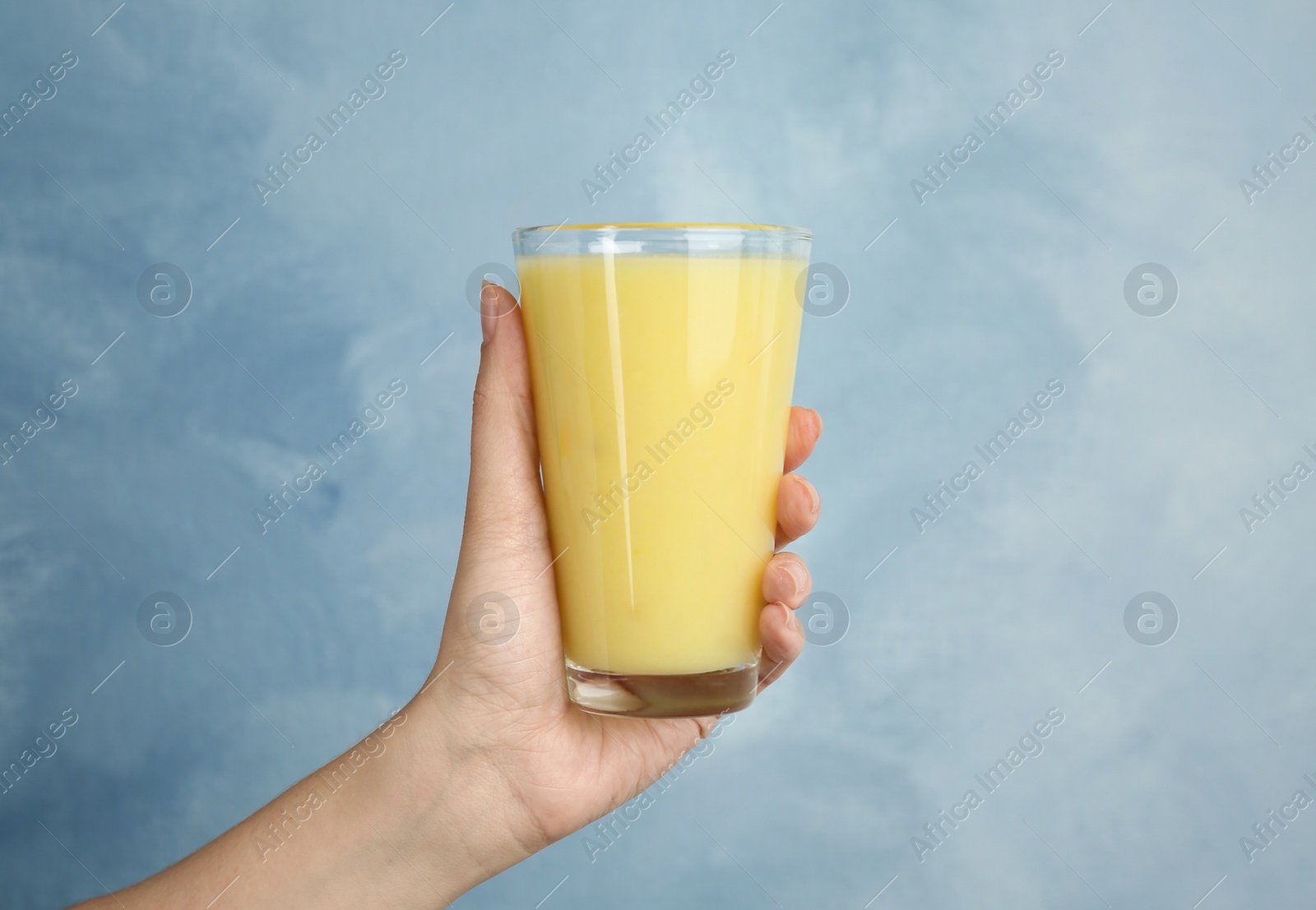 Photo of Woman holding glass with delicious smoothie on color background