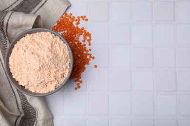 Photo of Bowl of lentil flour and seeds on white tiled table, flat lay. Space for text