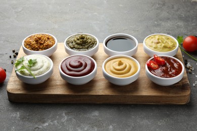 Many different sauces and products on grey table