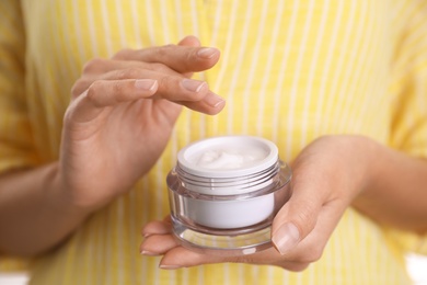 Woman with jar of moisturizing cream, closeup