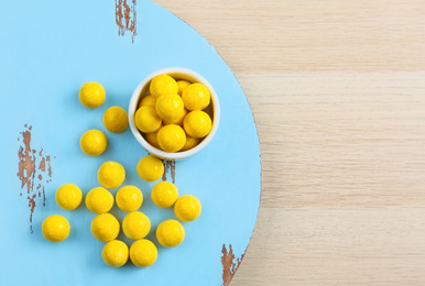 Photo of Tasty lemon drops on wooden table, flat lay. Space for text