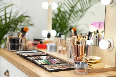 Photo of Set of luxury makeup products and accessories on dressing table with mirror. Space for text