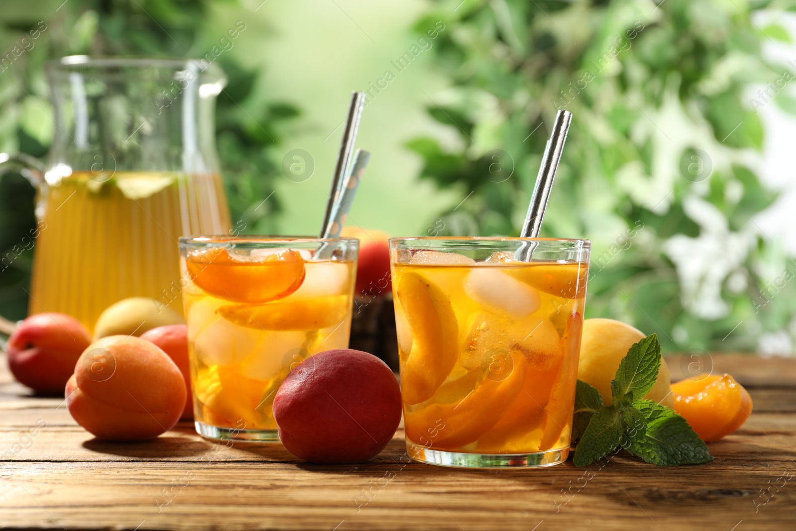 Photo of Delicious refreshing drink with apricot on wooden table