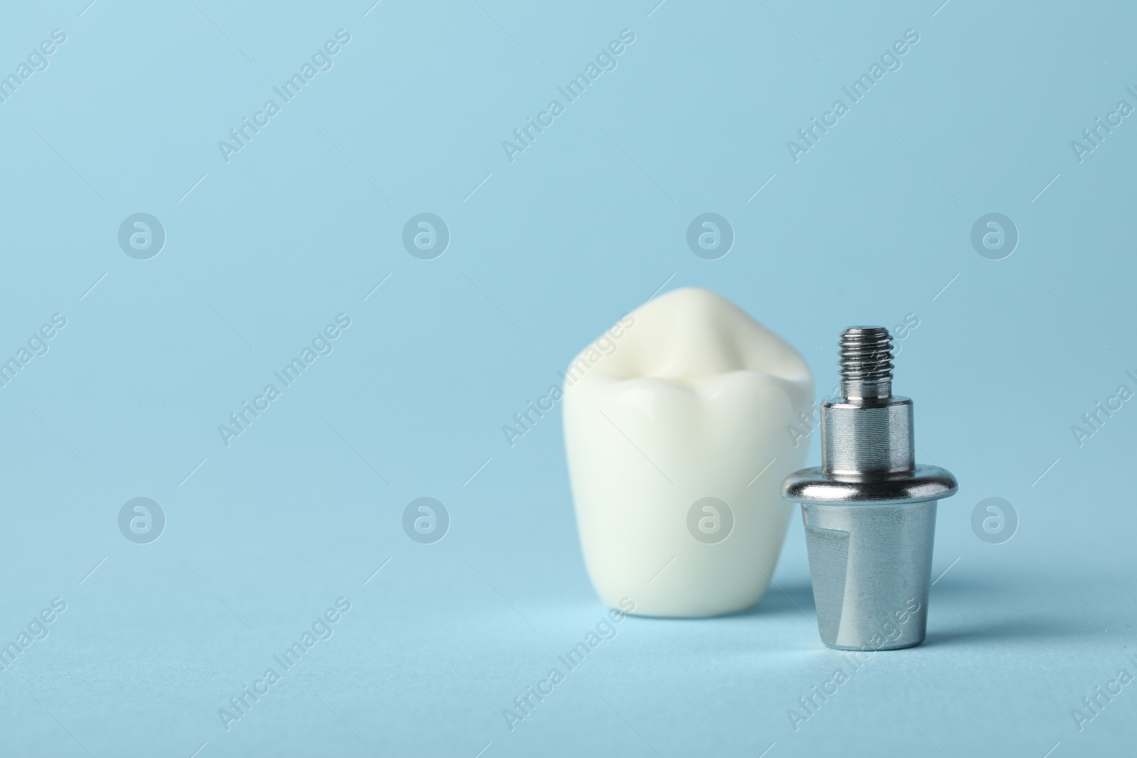 Photo of Abutment and crown of dental implant on light blue background, closeup. Space for text