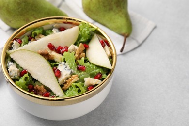 Photo of Delicious pear salad in bowl on light table, closeup. Space for text