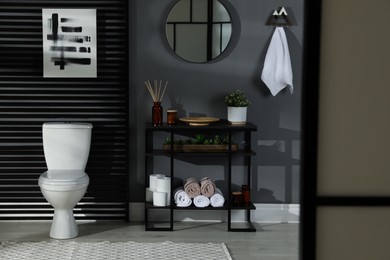 Photo of Modern bathroom interior with toilet bowl and console table