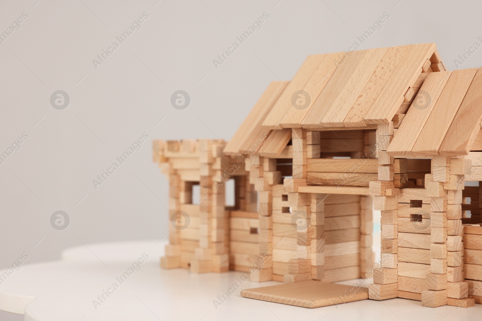 Photo of Wooden entry gate on table against light background, space for text. Children's toy