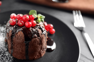 Delicious warm chocolate lava cake with mint and berries on table, closeup. Space for text