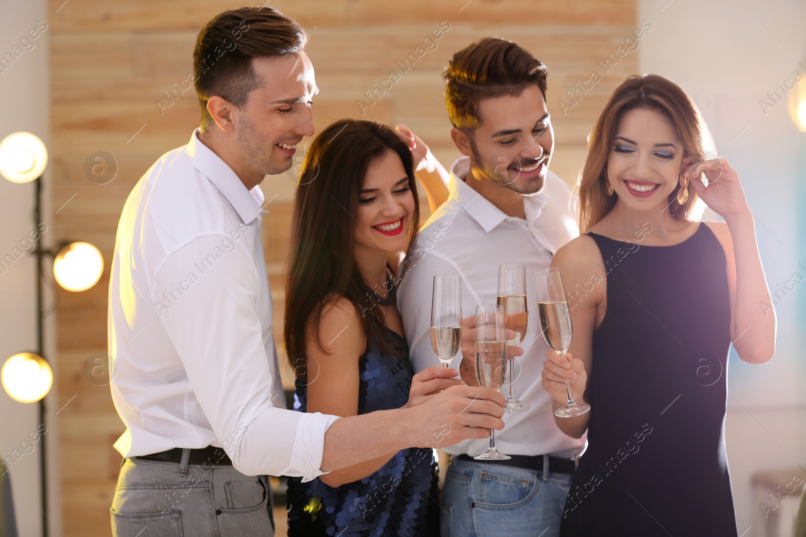 Photo of Friends clinking glasses with champagne at party indoors