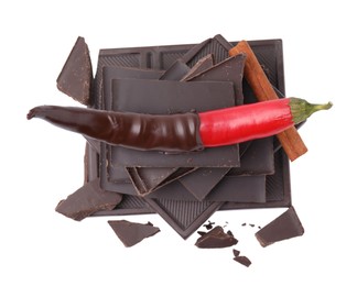 Photo of Red hot chili pepper and dark chocolate with cinnamon isolated on white, top view