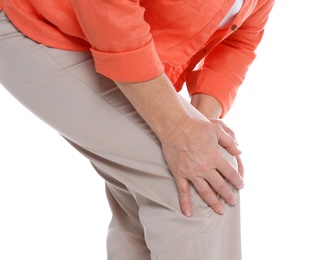 Woman suffering from knee pain on white background, closeup