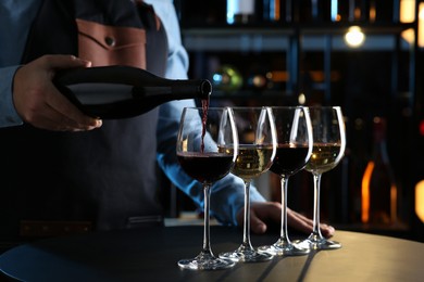 Photo of Bartender preparing wine tasting set at table indoors, closeup