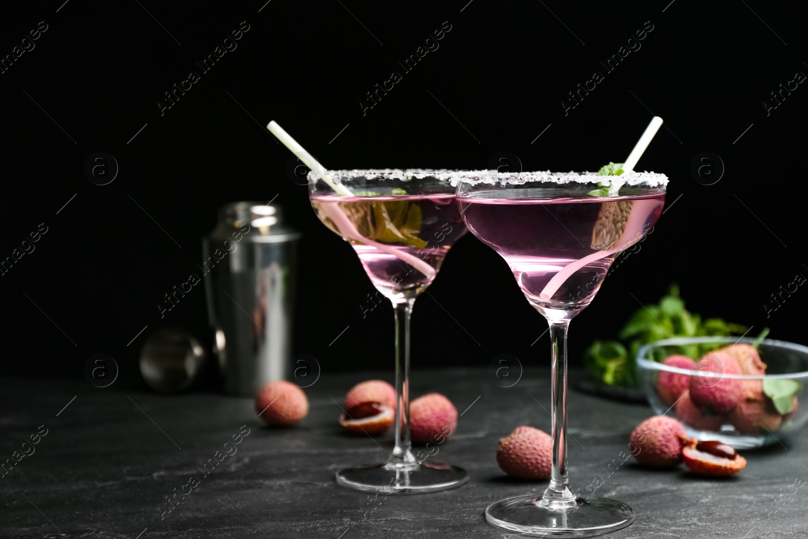 Photo of Delicious lychee cocktails and fresh fruits on black table. Space for text