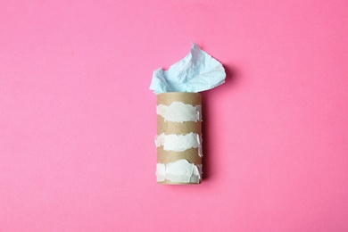 Photo of Flat lay composition with empty roll and toilet paper on color background