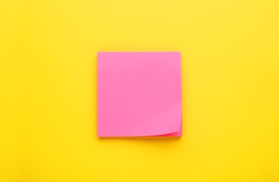 Photo of Paper note on yellow background, top view