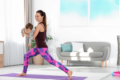 Photo of Woman doing fitness exercises together with son at home