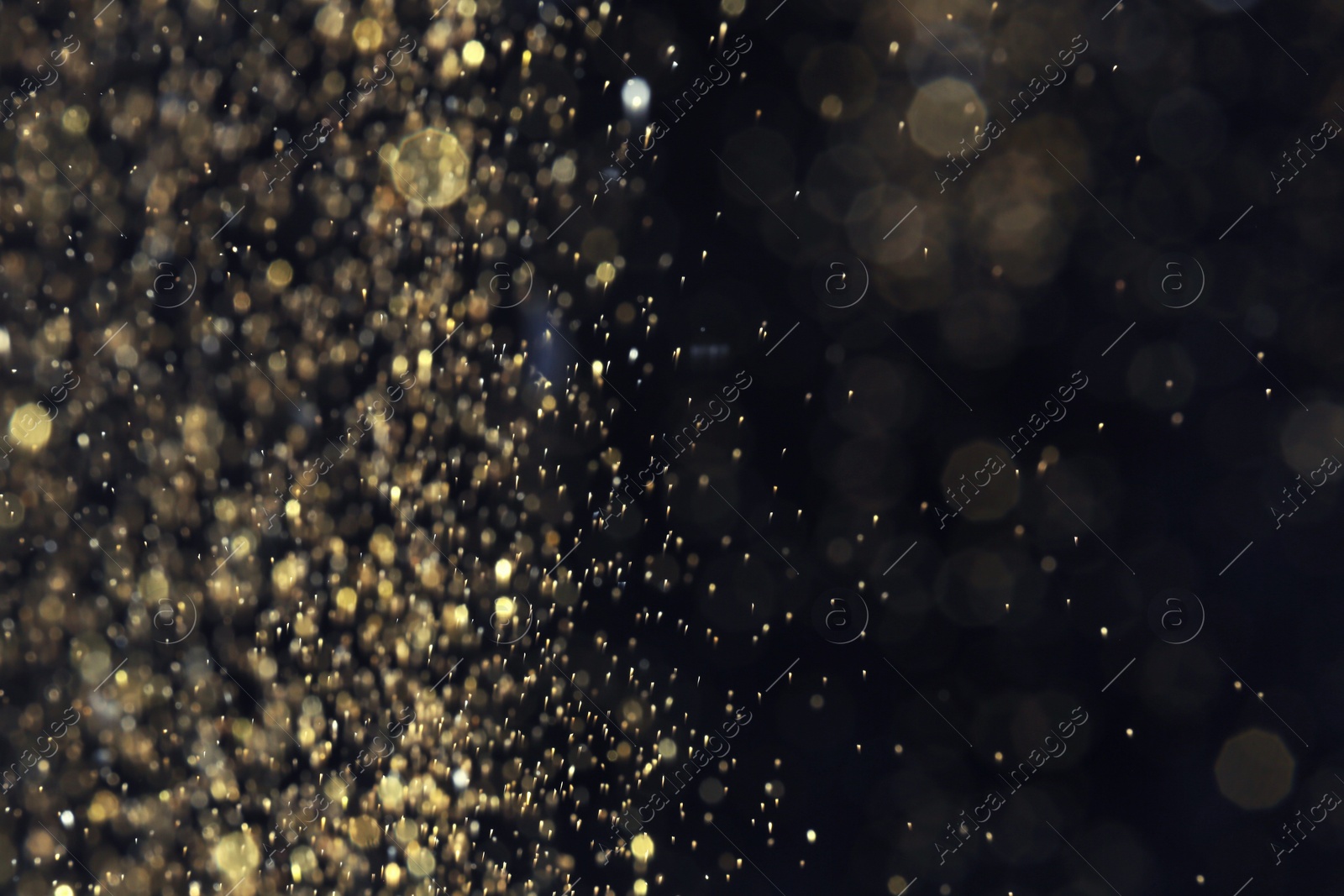 Photo of Golden glitter with bokeh effect on dark background