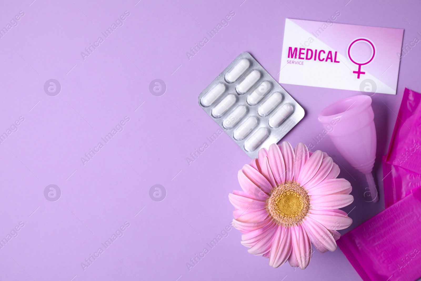 Photo of Flat lay composition with menstrual cup, pills and gerbera flower on color background, space for text. Gynecological care