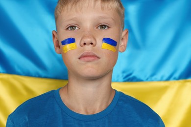 Photo of Little boy near Ukrainian flag. No war concept