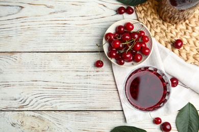 Delicious cherry wine with ripe juicy berries on white wooden table, flat lay. Space for text