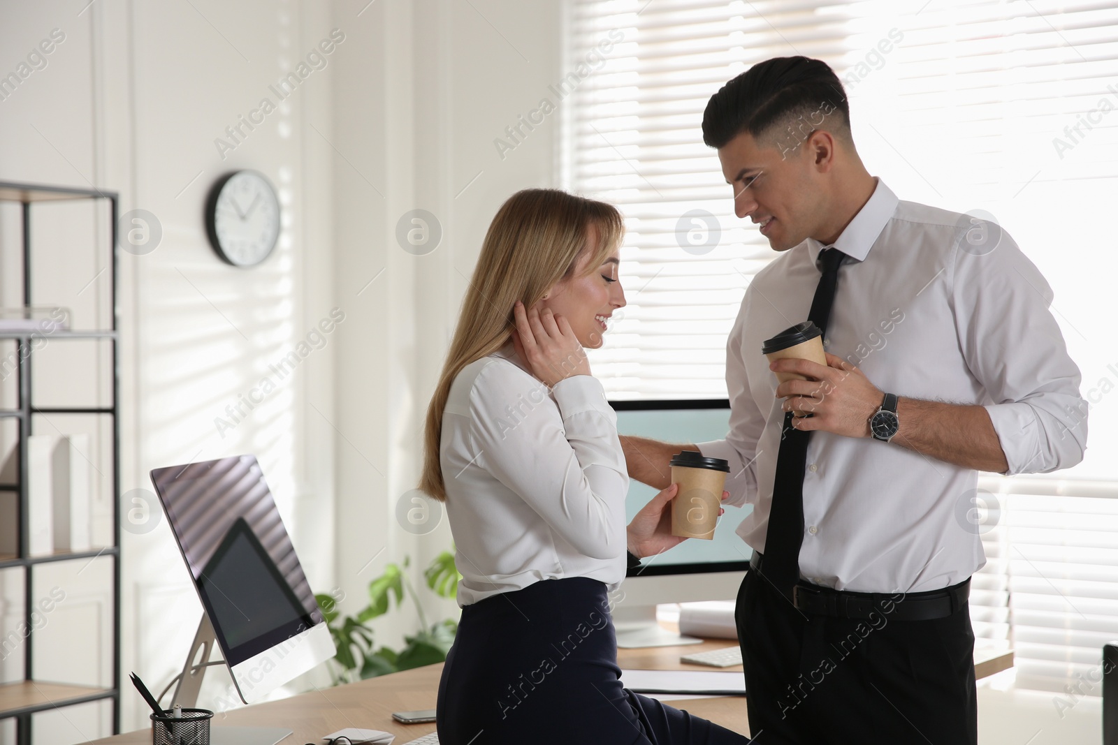 Photo of Colleagues flirting with each other during coffee break in office. Space for text