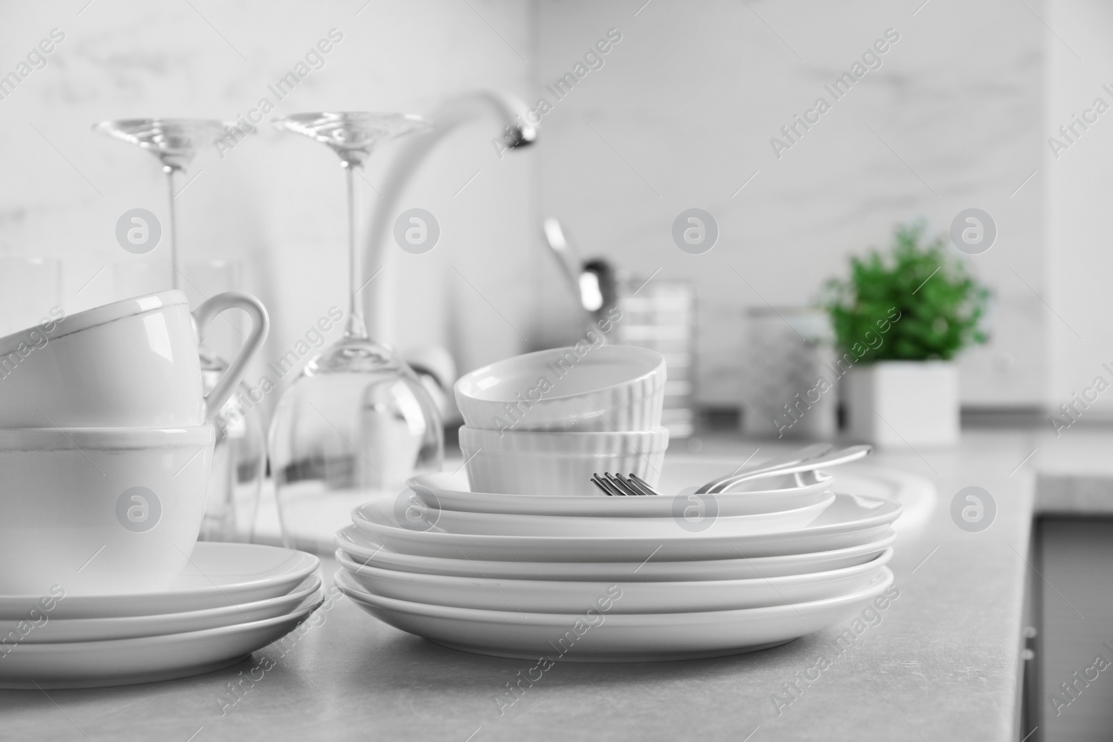 Photo of Set of clean dishes and cutlery on kitchen counter