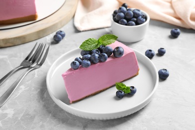 Photo of Plate with piece of tasty blueberry cake on light table