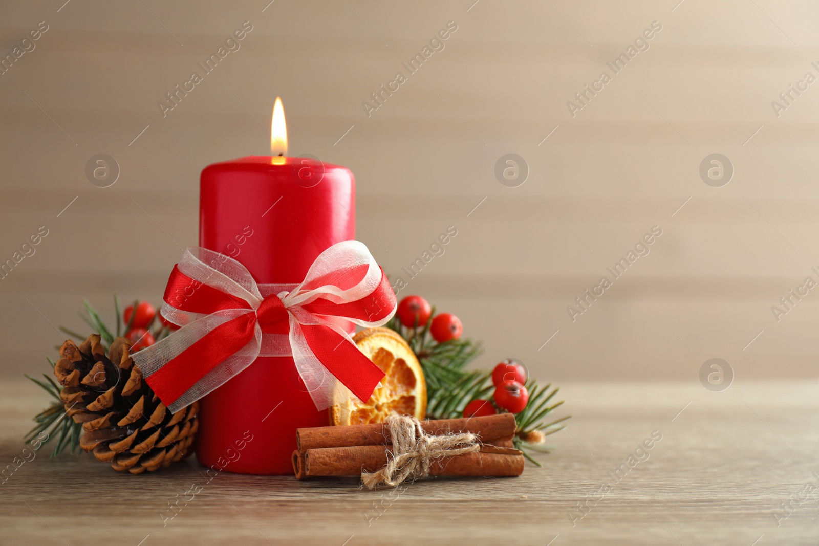 Photo of Beautiful composition with candle and Christmas decor on wooden table. Space for text