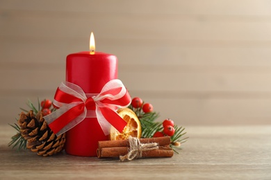 Photo of Beautiful composition with candle and Christmas decor on wooden table. Space for text