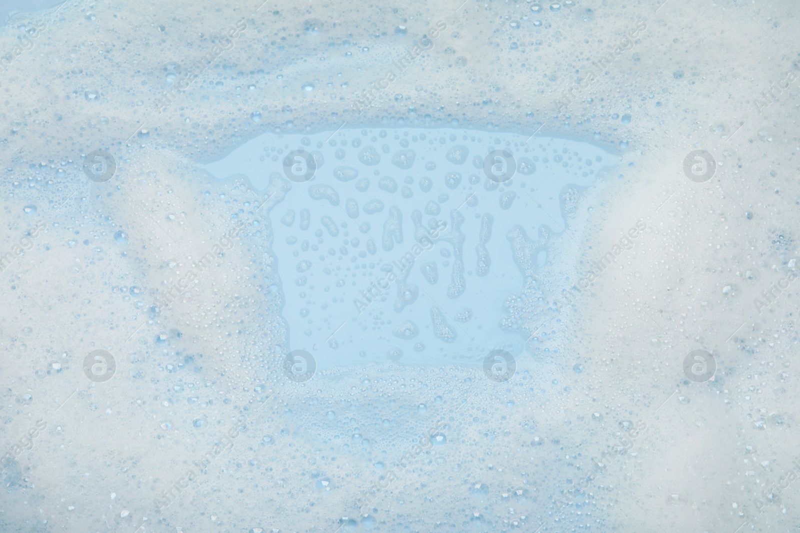 Photo of White washing foam on light blue background, top view