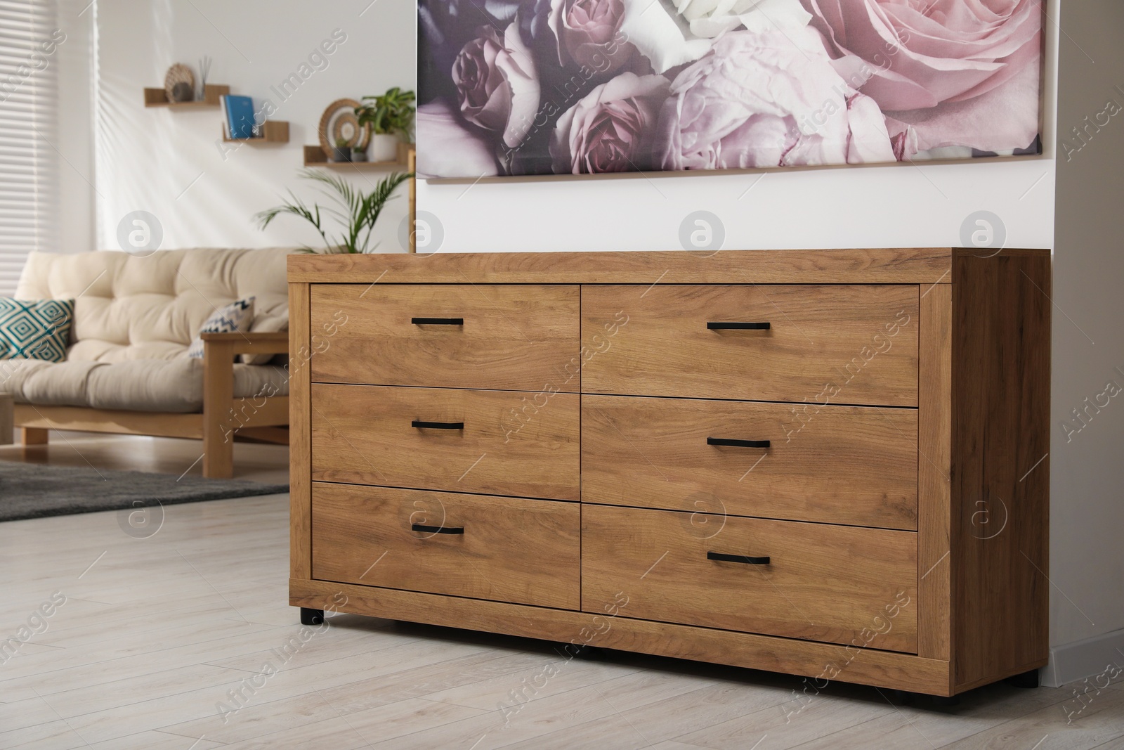 Photo of Wooden chest of drawers near white wall in stylish room