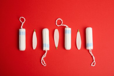 Photo of Tampons on red background, flat lay. Menstrual hygiene product