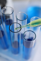 Photo of Laboratory analysis. Dripping liquid into test tubes indoors, closeup