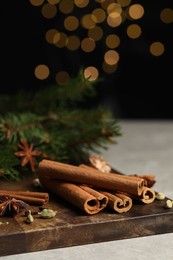 Photo of Board with different aromatic spices on light table, closeup. Space for text