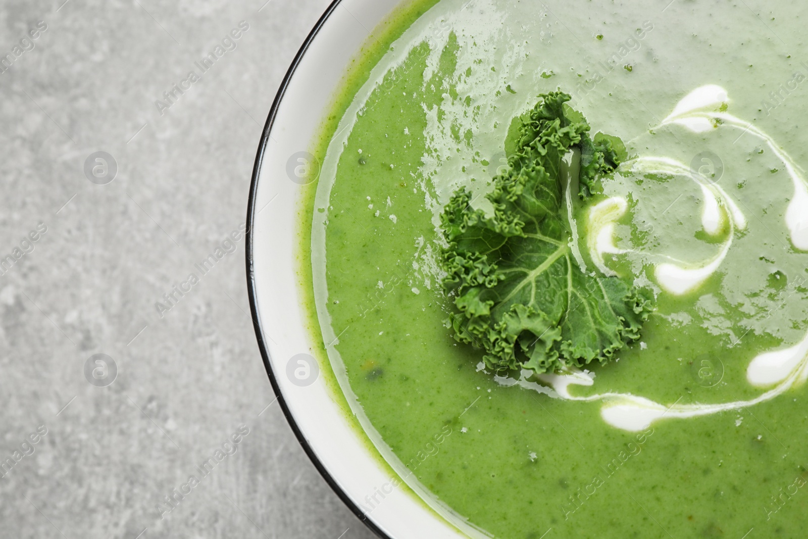 Photo of Tasty kale soup on grey table, top view