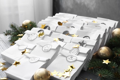 Photo of Christmas advent calendar with gifts and festive decor on grey wooden table