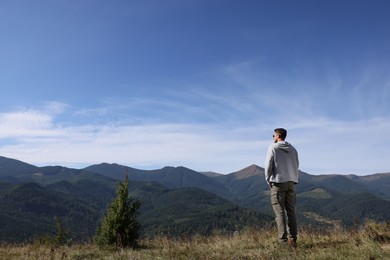 Photo of Man enjoying picturesque view of mountain landscape on sunny day